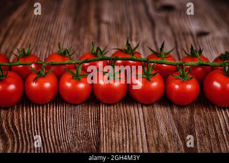 Rows of small ripe cherry tomatoes on wooden background Stock Photo