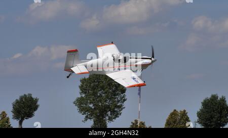 Ferrara Italy JUNE, 27, 2021 Small propeller aerobatic plane flying at low altitude with trees in the background. Corby CJ-1 Starlet single seat, amateur built airplane of the 1960s Stock Photo