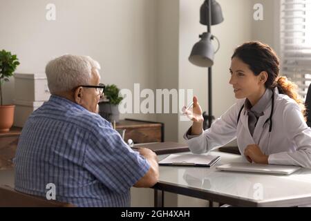 Elder male patient visiting doctor in office in hospital Stock Photo