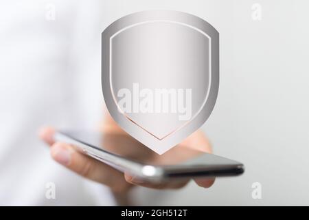 A concept of cybersecurity and information or network protection, 3d shield floating out of the mobile screen Stock Photo