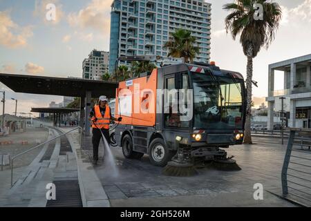 Tel Aviv, Israel - August 17th, 2021: A street sweeper at work, early morning, on the Lahat promenade, near the Tel Aviv, Israel, beach. Stock Photo