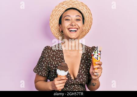Beautiful hispanic woman with short hair eating ice cream cones smiling and laughing hard out loud because funny crazy joke.