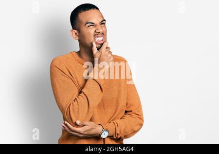Young african american man wearing casual clothes thinking worried about a question, concerned and nervous with hand on chin Stock Photo