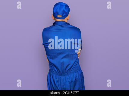 Bald man with beard wearing builder jumpsuit uniform hugging oneself happy and positive from backwards. self love and self care Stock Photo