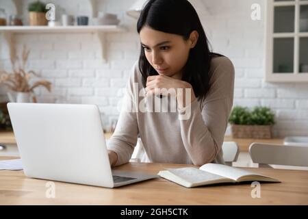Happy beautiful young asian woman studying online using computer. Stock Photo