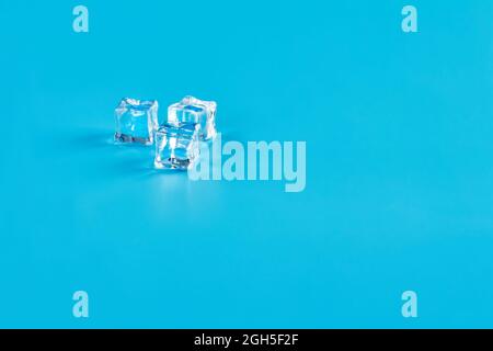 Three ice cubes on a blue background Stock Photo