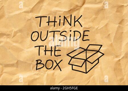 Text Think Outside The Box handwritten on crumpled brown paper. Creativity or innovation concept. Stock Photo