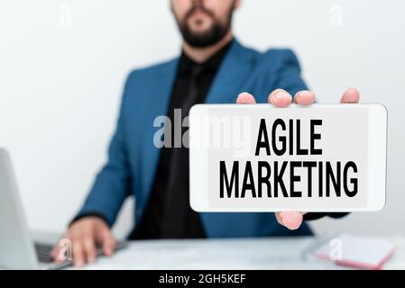 Writing displaying text Agile Marketing. Word for focusing team efforts that deliver value to the endcustomer Tech Guru Selling Newly Developed Device Stock Photo