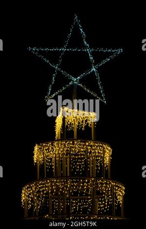 Christmas lights on tree with star close up outside for winter xmas festive themes Stock Photo