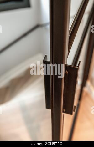 From above of metal door handle of modern glass door leading to staircase in house in minimal style Stock Photo