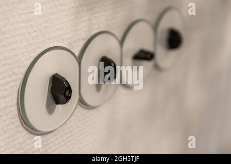 Closeup of row of light switches installed on white wall in modern apartment Stock Photo