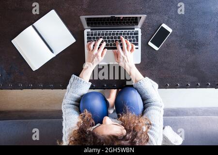 Top view of business Woman with curly hair sitting in the sofa and working with her laptop Stock Photo