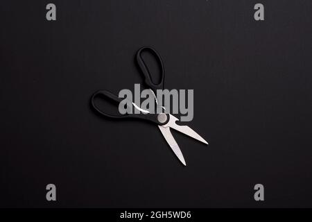 Kitchen utensils on black. Kitchen scissors on black background Stock Photo