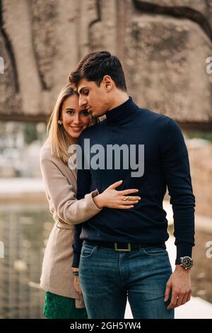 Young stylish couple standing close to each other in city street and  smiling Stock Photo - Alamy