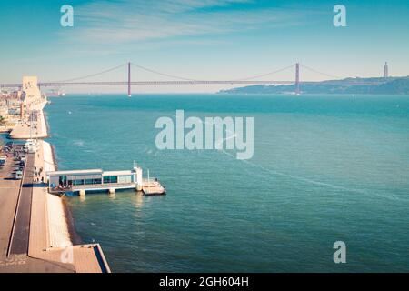 Drone view of contemporary quay located near embankment on coast of Tagus River near Torre de Belem Garden and not far from 25 de Abril Bridge at dayt Stock Photo