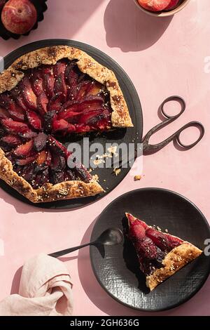 Close-up of a plum cake seen from above on a pink background Stock Photo