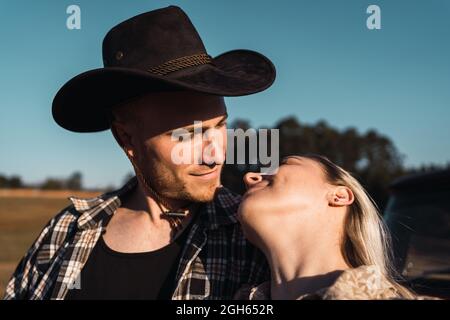 Young couple in love in sunset while looking at each other in summer Stock Photo