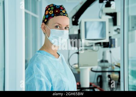 Cropped unrecognizable female standing with assorted fruits and vegetables in eco friendly mesh bag against blue wall in city Stock Photo