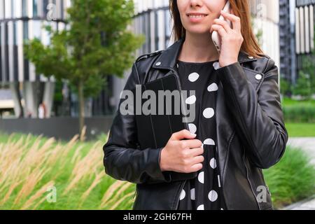 Modern business woman talking on the smart phone near the business center Stock Photo