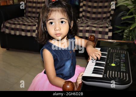 Adorable Cute Girl Playing Piano Concept Stock Photo