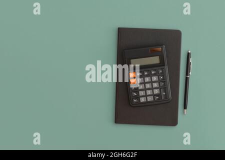 Calculator, notebook, pen on green background. Back to school Stock Photo