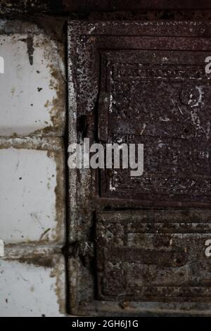 Defocus Old stove doors. Iron door close-up detailed decor in antique house. Vertical. Dirty brick. Out of focus. Stock Photo