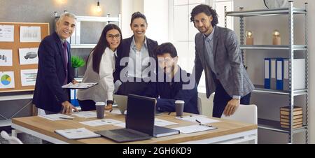 Portrait of a group of smiling diverse corporate colleagues at workplace in bright modern office. Stock Photo