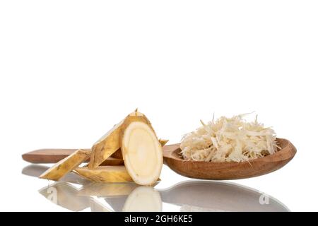 One sliced and grated horseradish roots with a wooden spoon, close-up, isolated on white. Stock Photo