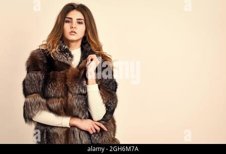 Woman makeup and hairstyle posing mink or sable fur coat. Winter elite luxury clothes. Female brown fur coat. Fur store model posing in soft fluffy Stock Photo