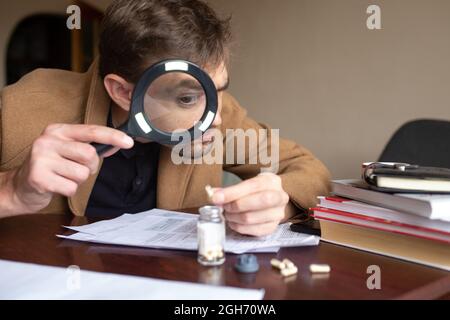 the detective is looking for prints at the crime scene Stock Photo