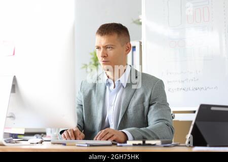 Portrait of caucasian business man working on laptop online in home office Stock Photo