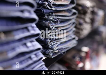 Stack of blue jeans in different shades at store closeup Stock Photo