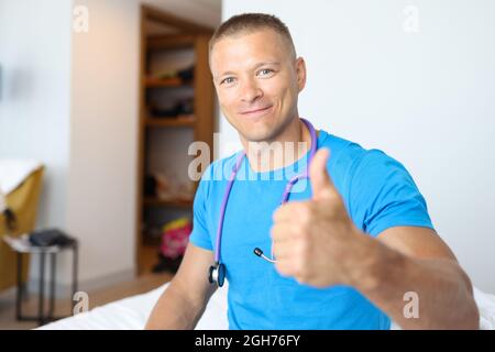 Smiling male doctor making thumbs up gesture Stock Photo