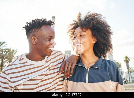 Portrait medium shot of a young black couple looking at each other smiling. Concept of family, brothers, sisters, friends, relationship. Stock Photo