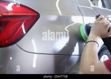 Master polishing car using special machine closeup Stock Photo