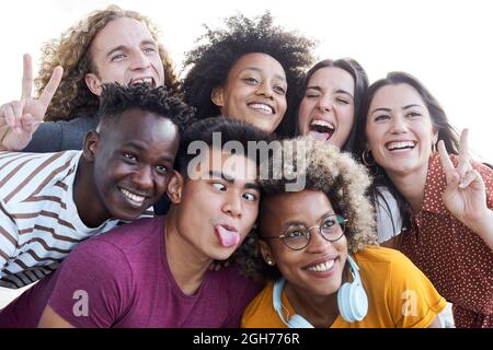 Portrait of friends take a picture with a mobile phone. Multiethnic concept, selfie, friendship, play the fool. Stock Photo