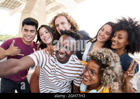 Portrait of friends take a picture with a mobile phone. Multiethnic concept, selfie, friendship. Stock Photo