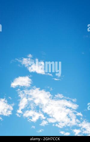 Background with blue sky and small white clouds at the bottom in vertical format Stock Photo