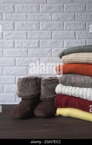 Knitted warm sweaters and slippers. Autumn and winter clothes. Stock Photo