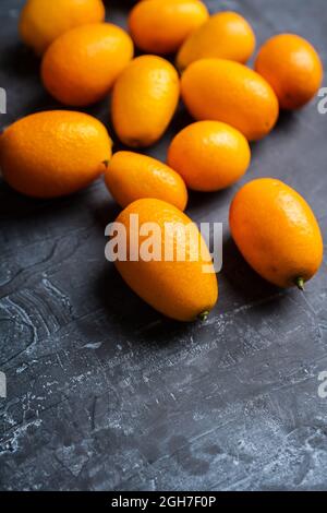 Fresh ripe kumquats on the rustic wooden background. Selective focus. Shallow depth of field. Stock Photo