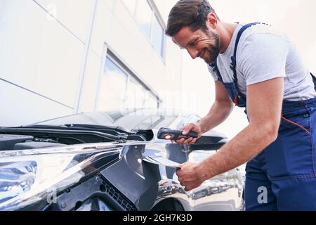 Caucasian repair service mechanic choosing colour for painting car Stock Photo