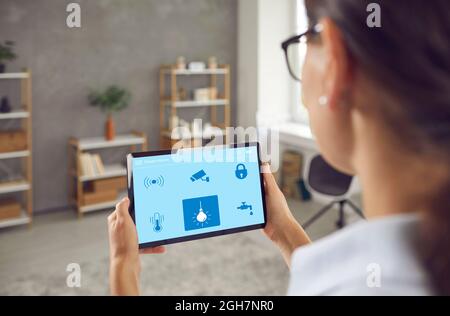 Woman controls electric power in her Smart House using an app on a digital tablet Stock Photo
