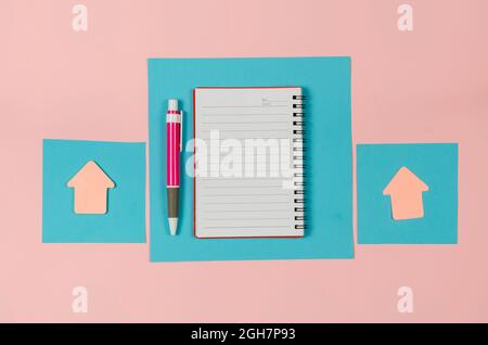 Sheets of a paper, open notebook, arrow bookmarks, pen on pink b Stock Photo
