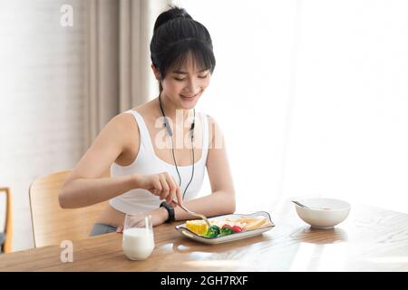 Young woman having breakfast at home Stock Photo