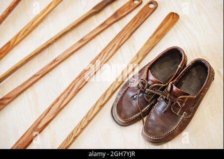 Hand carved oak wooden shoe horn. Shoes accessories. Home styling spoon. Stock Photo