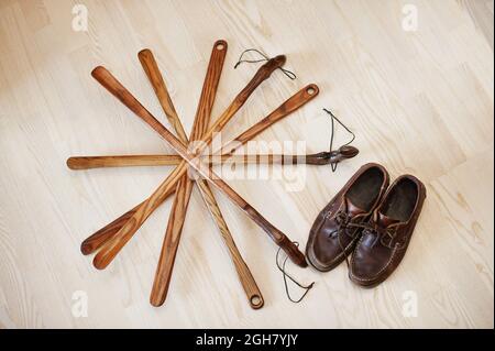 Hand carved oak wooden shoe horn. Shoes accessories. Home styling spoon. Stock Photo