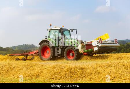 Tractor Raking Fields Tractor in a field raking straw with a rotary hay rake in preparation ...