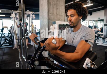Young handsome man doing exercises in gym Stock Photo