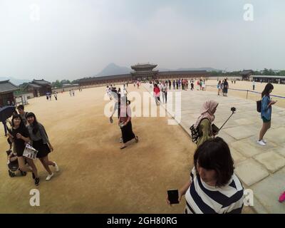 Crowd of people in the courtyard of Gyeongbokgung Palace. Clouds in blue sky. Stock Photo