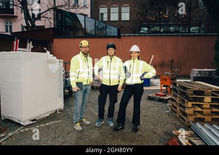 Full length portrait of confident male and female engineers standing at construction site Stock Photo